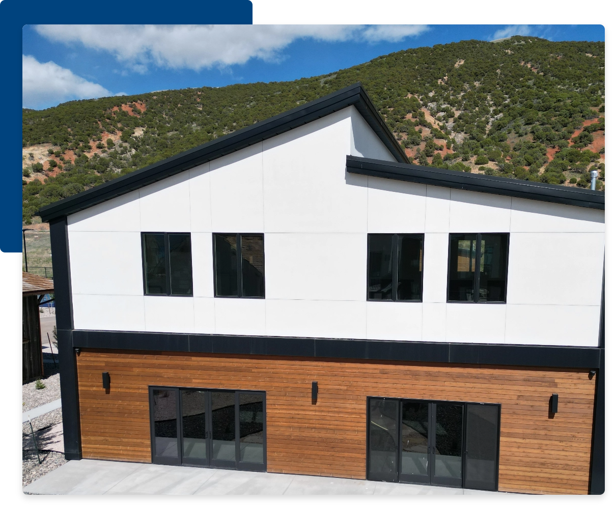 Best Siding Type for Your Climate, picture of a partially-white structure near hills or mountains